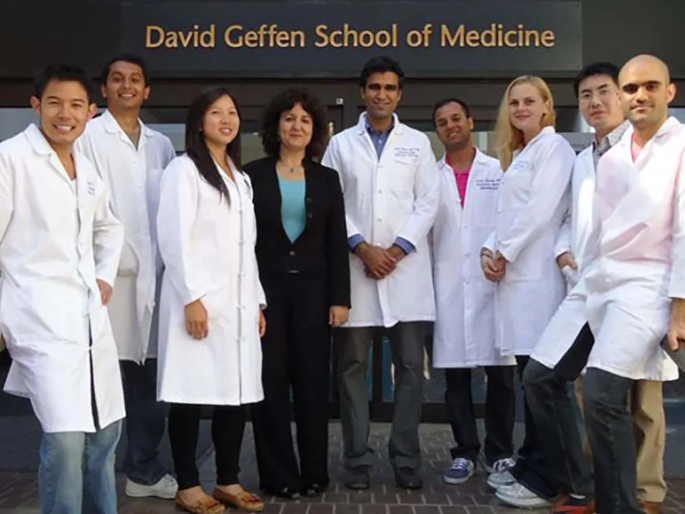 Group in lab coats standing in front of David Geffen School of Medicine sign