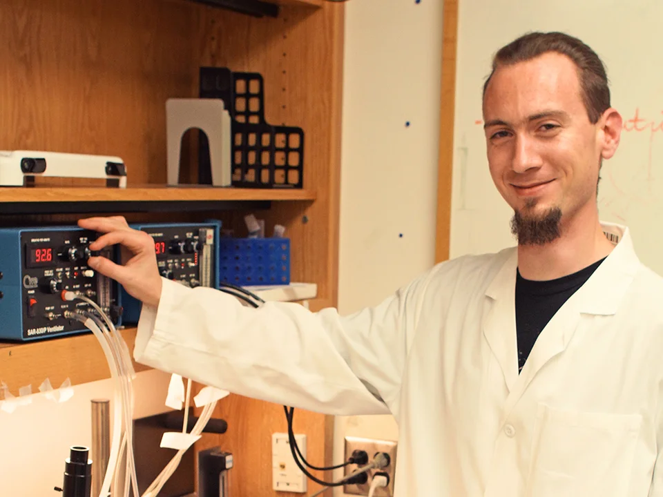 Man in white coat working in lab