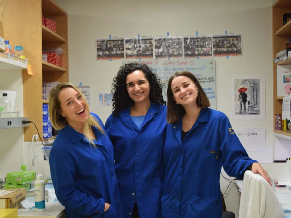 3 women wearing blue coats in the lab